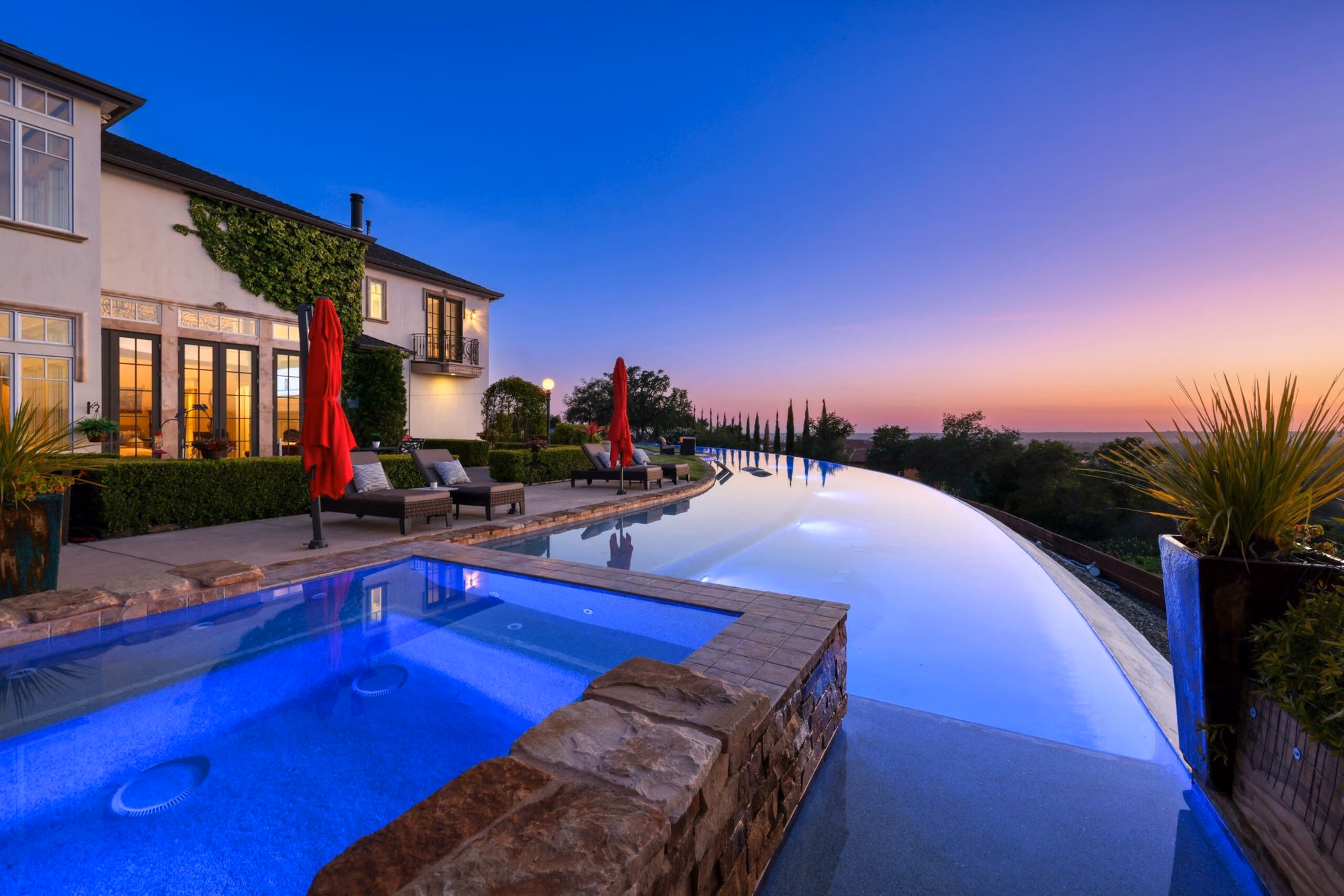 An infinity-edge pool at a foothill estate at twilight