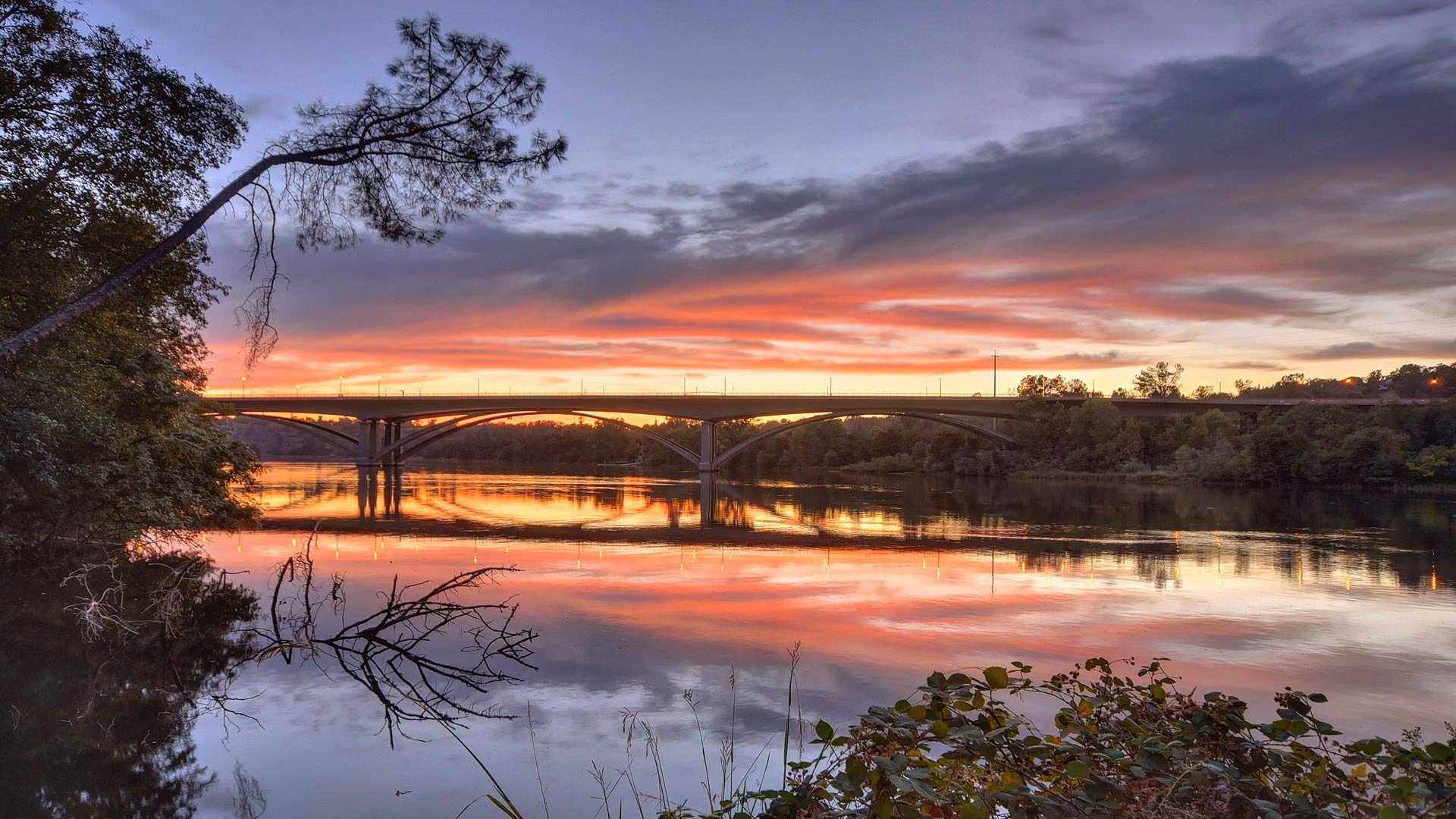 Sunset over a river bridge in the Sacramento region